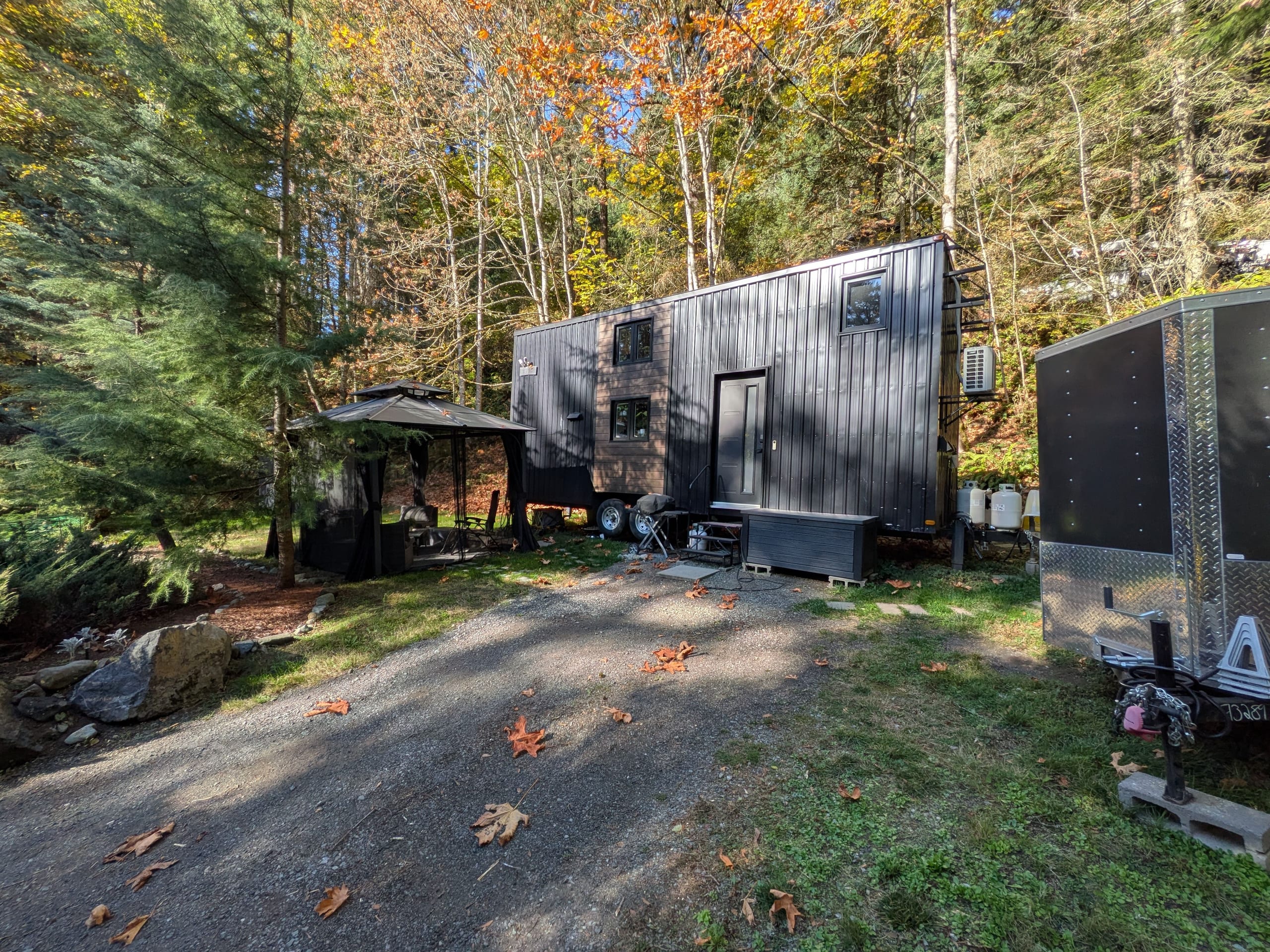 Gravel driveway and parking area beside the tiny house, gazebo and sheds